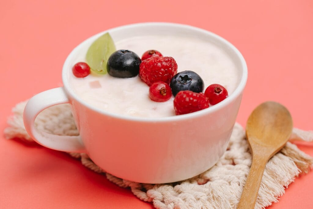 Happy Baby Organic Yogis freeze-dried yogurt snacks in pouch packaging with fruit scattered
